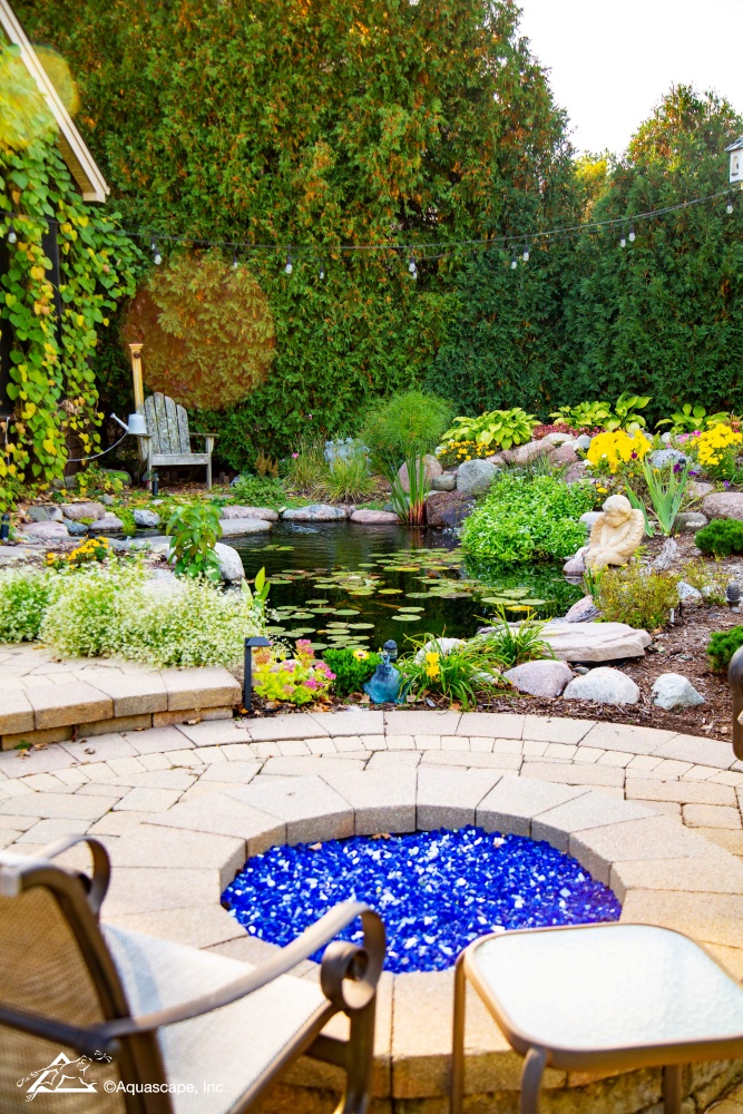 fire pit on patio by water garden