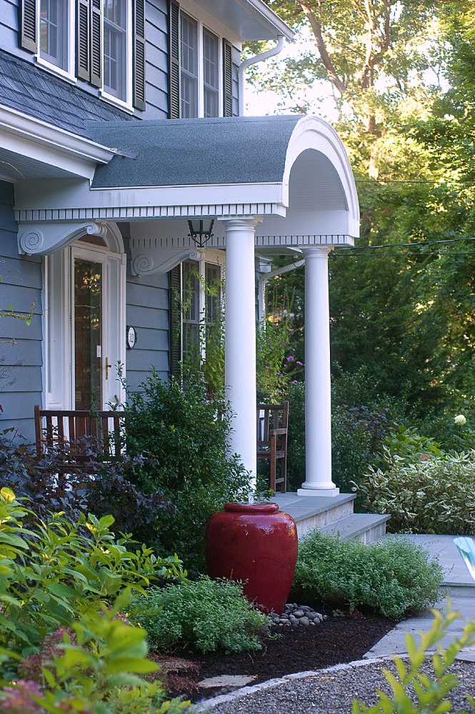 Portico and plantings at front entry of Dutch Colonial home